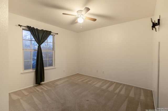 spare room featuring carpet flooring and ceiling fan