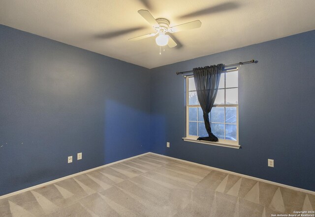 unfurnished room featuring ceiling fan and carpet floors