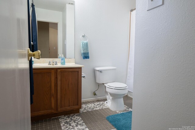 bathroom featuring toilet, vanity, and tile patterned floors