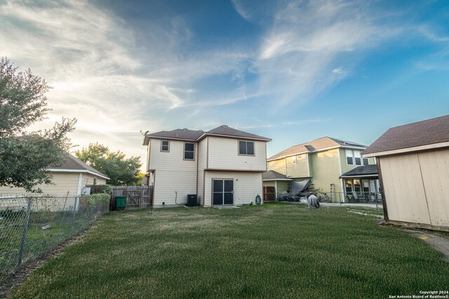 rear view of property with cooling unit and a lawn