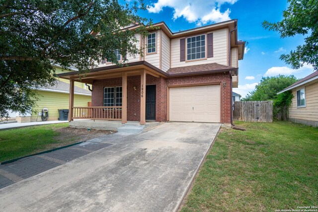 view of front of home with a front yard, a porch, and a garage