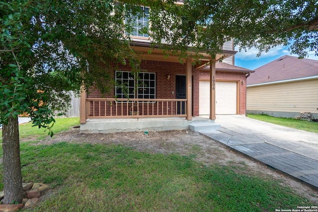 view of front of house featuring a porch, a garage, and a front lawn