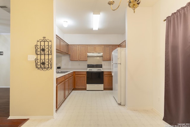 kitchen featuring a notable chandelier, white appliances, sink, and hanging light fixtures