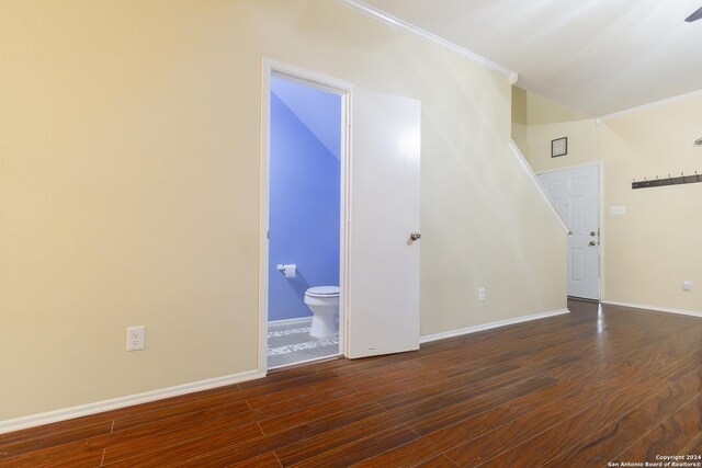 empty room with dark hardwood / wood-style flooring and ornamental molding