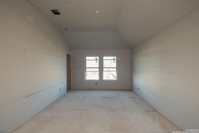 unfurnished room featuring lofted ceiling