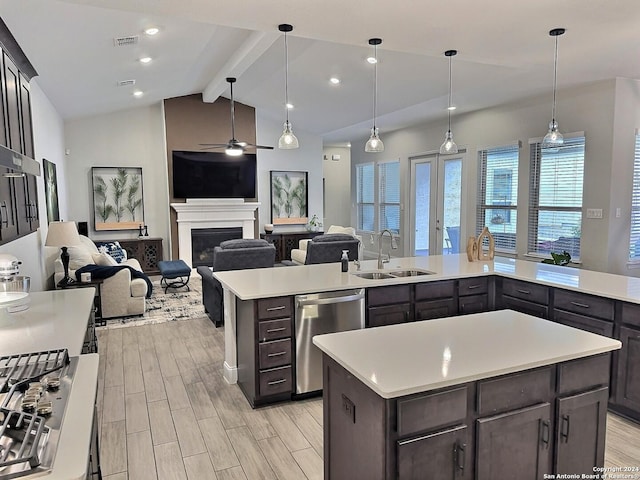 kitchen featuring dishwasher, sink, vaulted ceiling with beams, decorative light fixtures, and light wood-type flooring