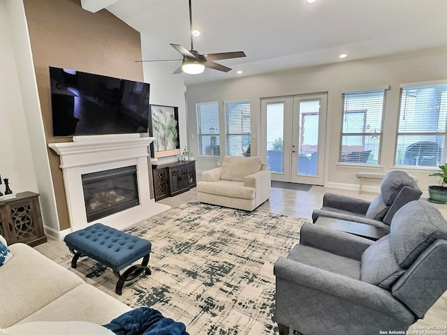 living room with french doors, light wood-type flooring, ceiling fan, and lofted ceiling