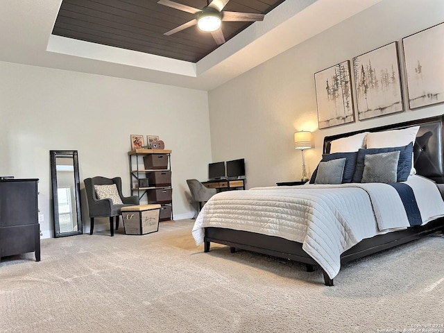 bedroom with carpet, a tray ceiling, and ceiling fan