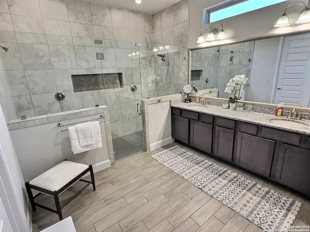 bathroom with a shower with door and vanity