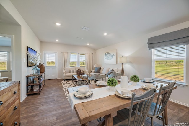 dining room with dark hardwood / wood-style flooring and lofted ceiling