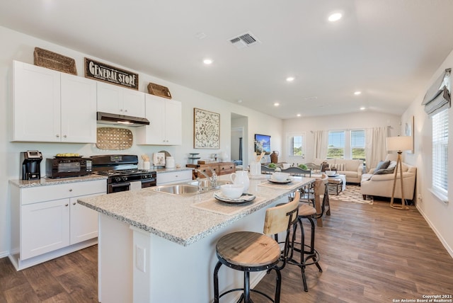 kitchen with sink, a center island with sink, white cabinets, black gas range, and dark hardwood / wood-style floors