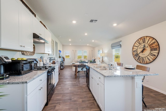 kitchen with sink, dark hardwood / wood-style floors, a breakfast bar area, and black appliances