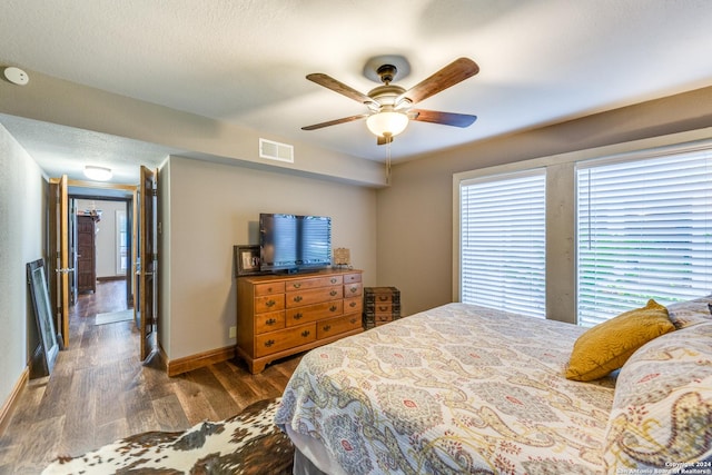 bedroom with a textured ceiling, dark hardwood / wood-style floors, and ceiling fan