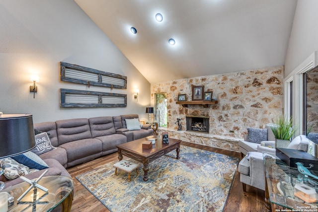 living room featuring wood-type flooring, a fireplace, and high vaulted ceiling