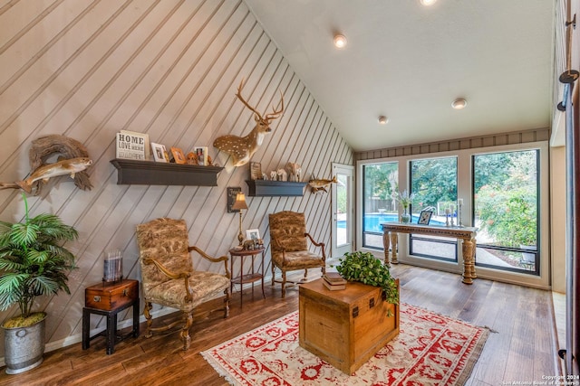 sitting room with dark wood-type flooring and high vaulted ceiling