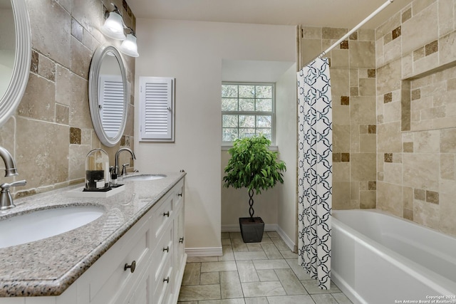 bathroom with vanity, shower / bathtub combination with curtain, and tile walls