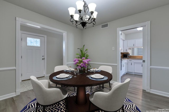 dining space featuring a notable chandelier and light wood-type flooring