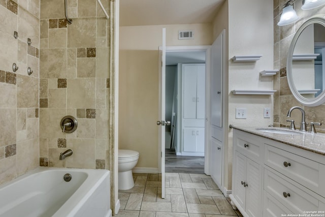 full bathroom with toilet, vanity, and tiled shower / bath