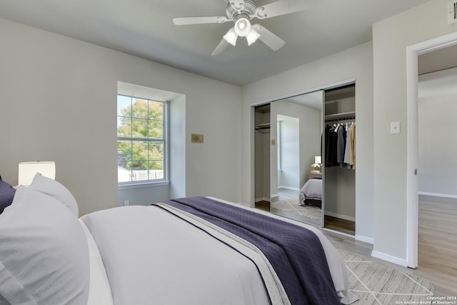 bedroom featuring ceiling fan, a closet, and light wood-type flooring