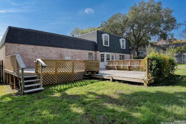 back of house featuring a wooden deck and a lawn