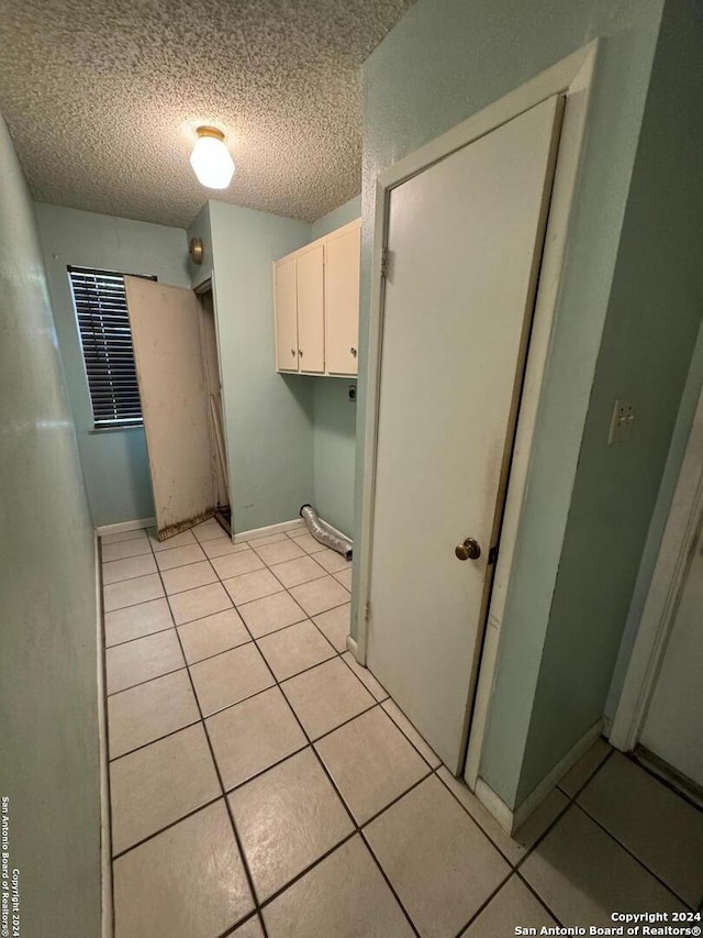 laundry room with light tile patterned floors and a textured ceiling