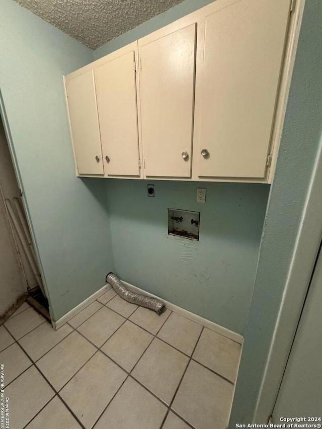 washroom with cabinets, washer hookup, light tile patterned floors, and electric dryer hookup