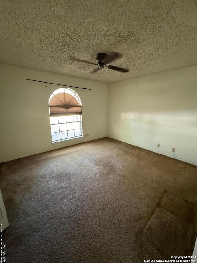 spare room with carpet flooring, a textured ceiling, and ceiling fan