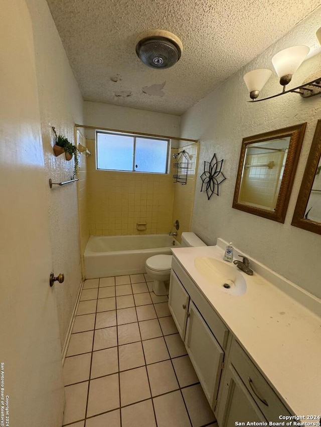 full bathroom with vanity, tile patterned flooring, tiled shower / bath combo, toilet, and a textured ceiling