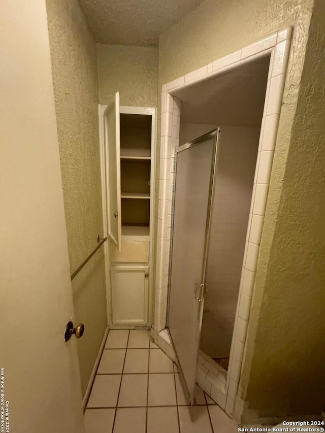 bathroom with tile patterned floors and an enclosed shower