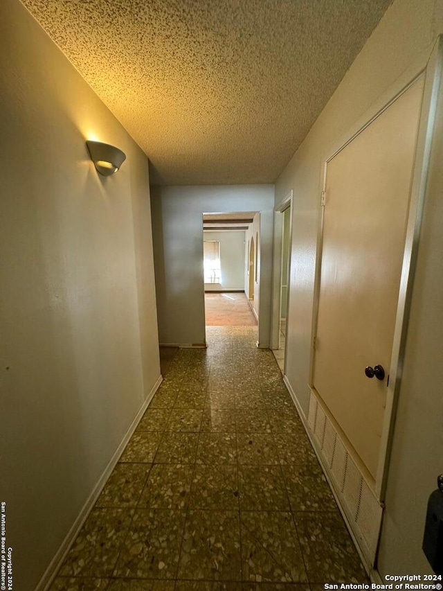 corridor featuring a textured ceiling