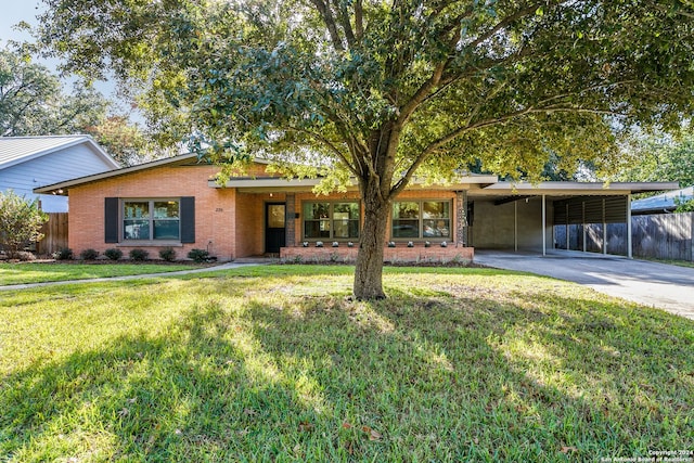 ranch-style home featuring a front yard and a carport