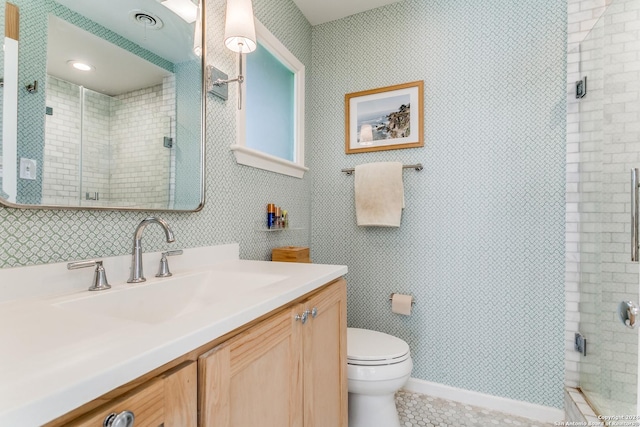 bathroom featuring toilet, a shower with door, and vanity