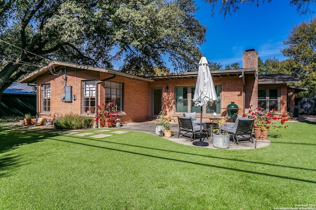 back of house with a lawn and a patio area