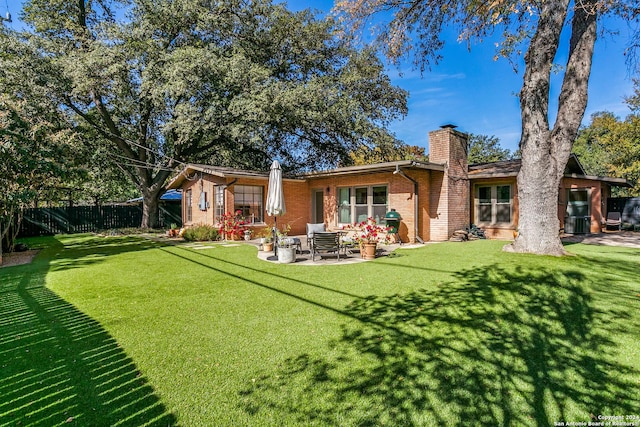 back of property featuring a patio area and a lawn