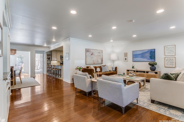 living room with hardwood / wood-style flooring and crown molding