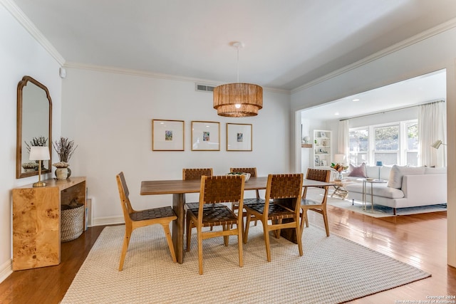 dining room featuring dark hardwood / wood-style flooring and crown molding