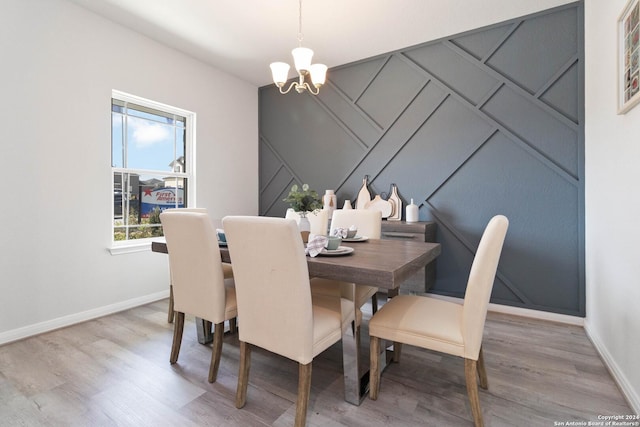 dining room with a healthy amount of sunlight, a notable chandelier, and hardwood / wood-style flooring