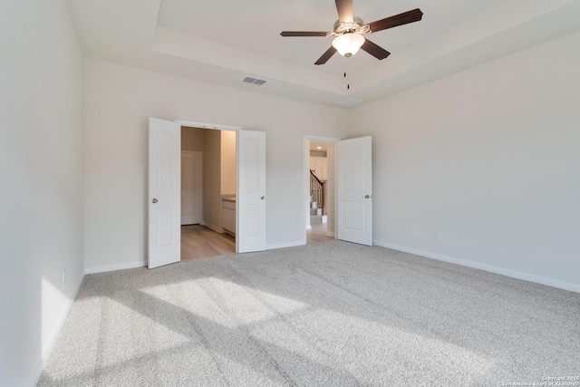 142 Ashley Loop, San Antonio, TX 78253 - unfurnished bedroom with light colored carpet, a tray ceiling, ensuite bath, and ceiling fan