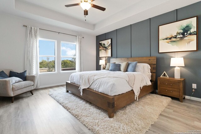 142 Ashley Loop, San Antonio, TX 78253 - bedroom with light wood-type flooring, a tray ceiling, and ceiling fan
