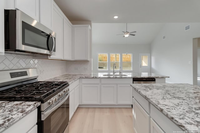 142 Ashley Loop, San Antonio, TX 78253 - kitchen with appliances with stainless steel finishes, ceiling fan, light wood-style flooring, backsplash, and vaulted ceiling