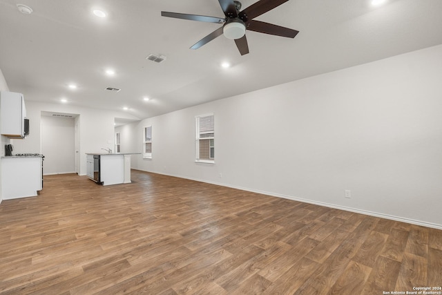 unfurnished living room with ceiling fan, light hardwood / wood-style floors, and lofted ceiling