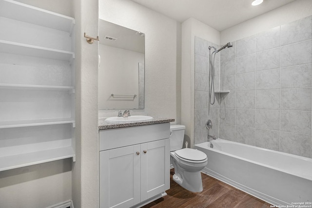 full bathroom with hardwood / wood-style floors, vanity, toilet, and tiled shower / bath