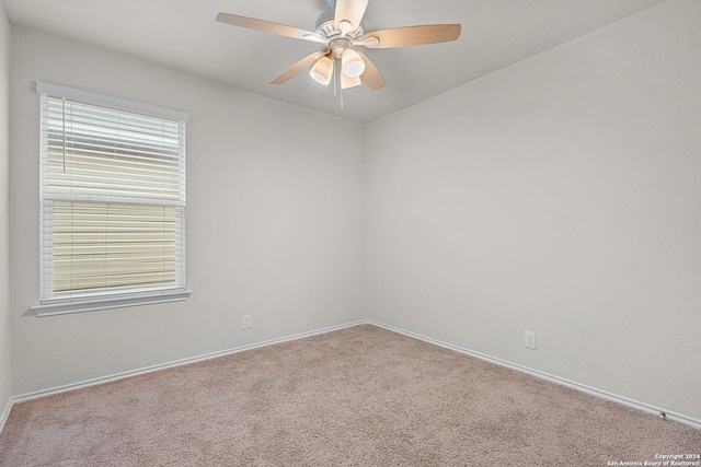 carpeted spare room with ceiling fan