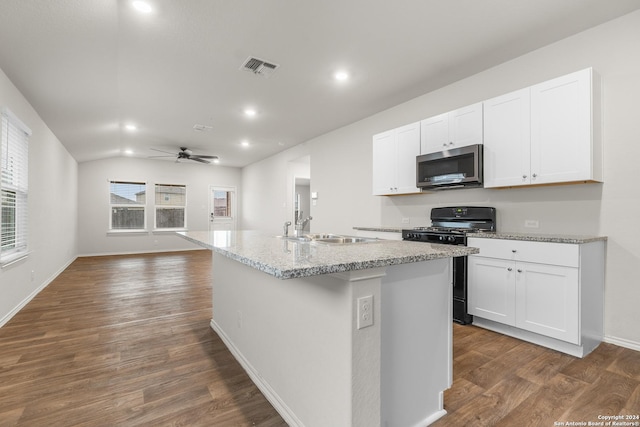 kitchen with gas stove, a kitchen island with sink, dark wood-type flooring, sink, and white cabinetry