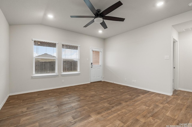 empty room featuring dark hardwood / wood-style flooring, vaulted ceiling, and ceiling fan