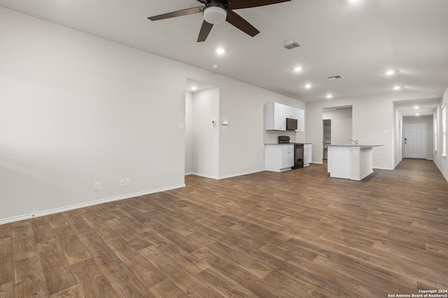 unfurnished living room with ceiling fan and dark wood-type flooring