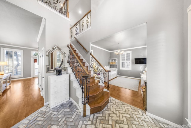 stairs featuring hardwood / wood-style floors, an inviting chandelier, and crown molding