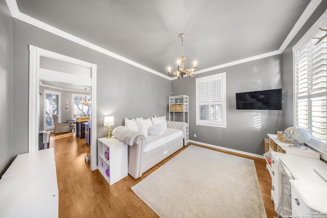 living room with light wood-type flooring, an inviting chandelier, and ornamental molding