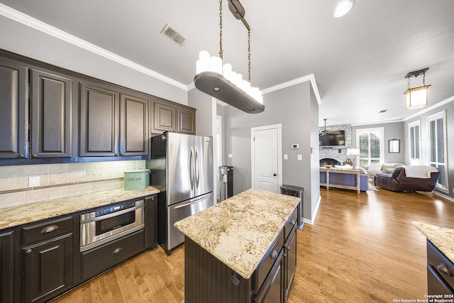 kitchen featuring ornamental molding, a center island, stainless steel appliances, and light hardwood / wood-style floors