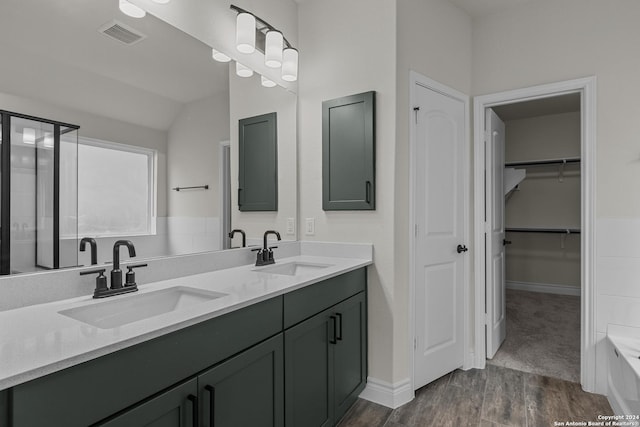 bathroom with hardwood / wood-style floors, vanity, and lofted ceiling